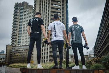 3 creatives club members wearing branded clothing and the branded camera strap